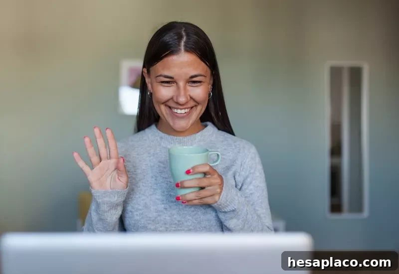 Woman waving at laptop