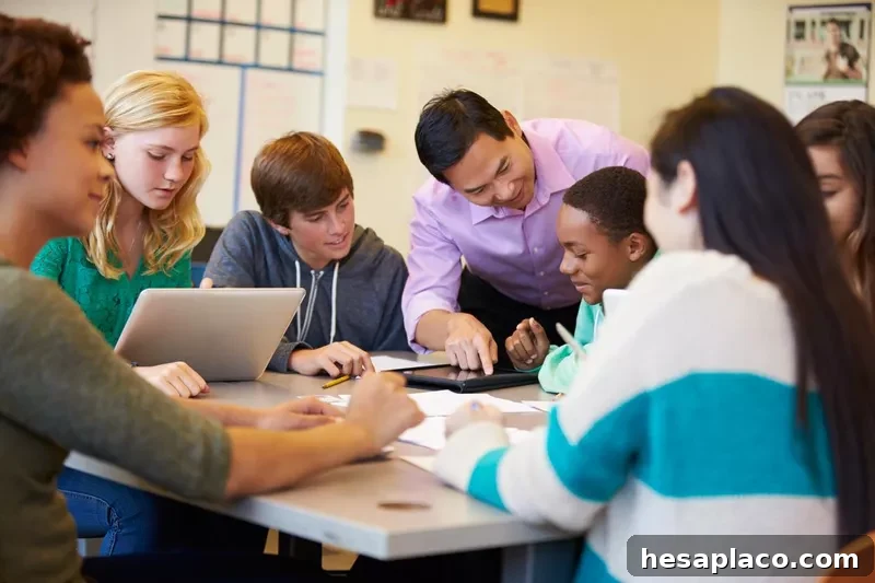 High school students with teacher in class using laptops