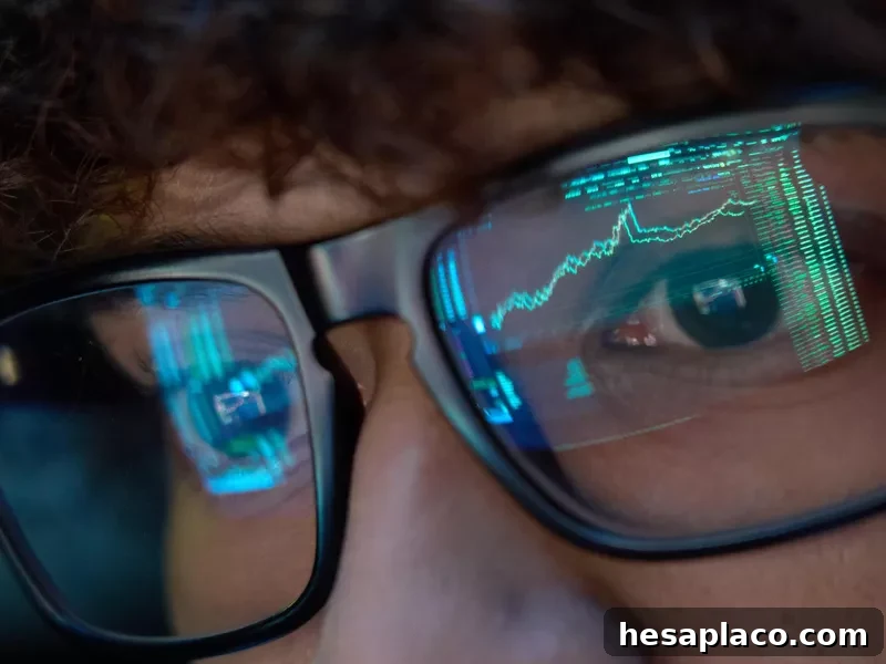 Young businessman looking at trading charts reflecting in his glasses