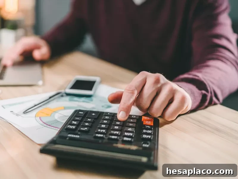 Man using a calculator and laptop