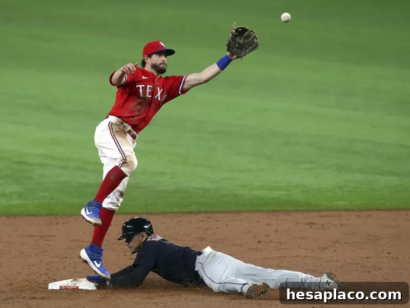 Texas Rangers second baseman Nick Solak leaps to catch ball as Cleveland Indians Andres Gimenez steals