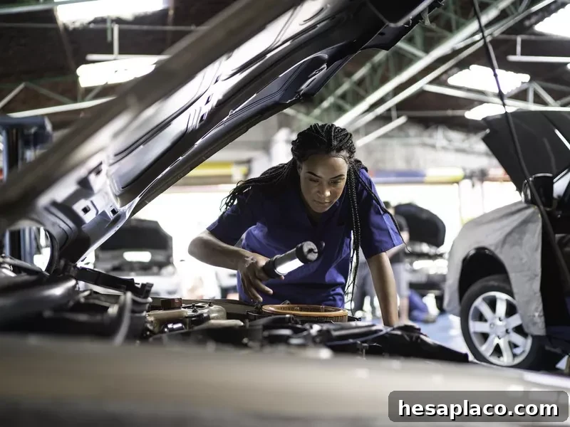 Woman repairing a car in auto repair shop